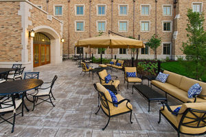 Wind Family Fireside Terrace - Gold and blue lounge chair sets decorate the patio. Black iron tables with chairs also decorate this outside area.